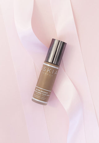 Nutri-Bronze Sheer Tinted Serum on a pink background